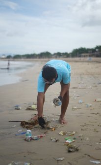 Man Collecting Garbage from Beach